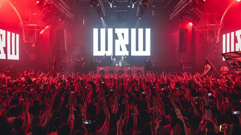 W&W playing CLUB GALAME under red light, with the floor packed in front of the stage